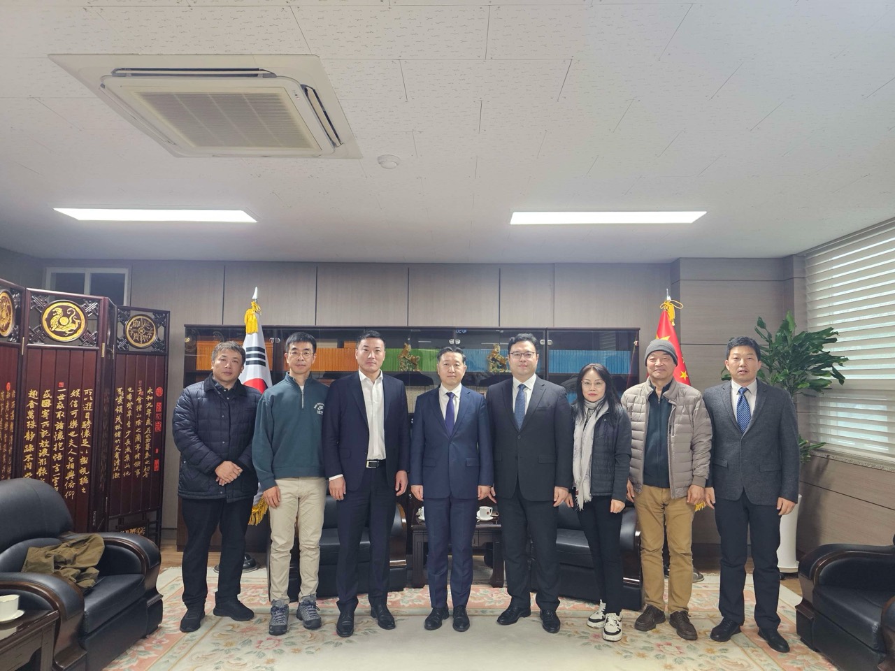 한국과 중국 국기가 놓인 실내에서 나란히 서서 기념 촬영하는 사람들